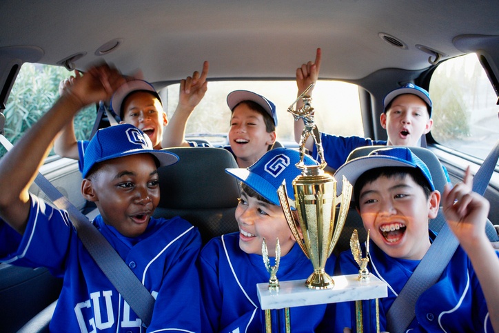boys in the car with baseball trophy