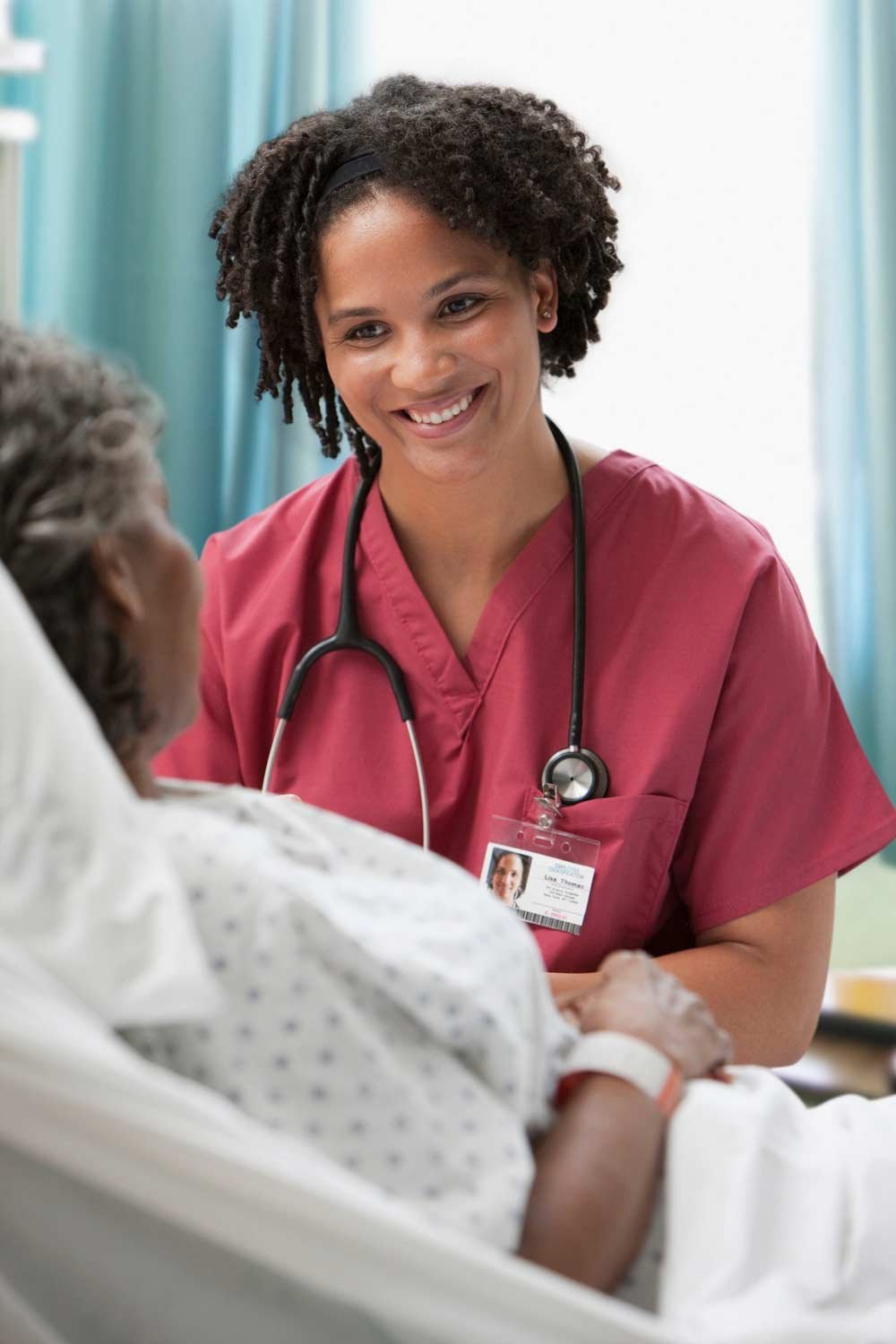 healthcare provider smiling and listening to hospital patient