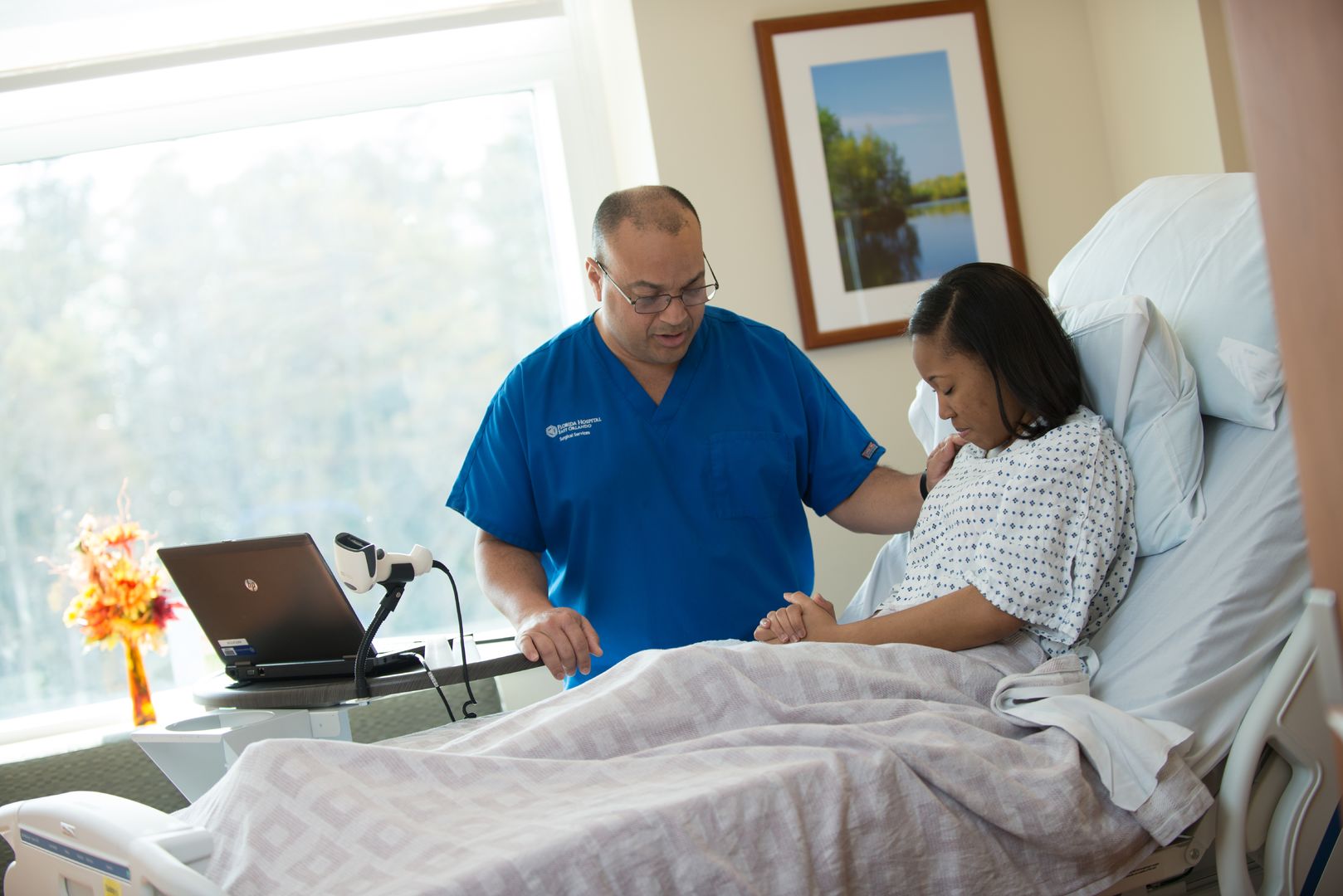 nurse praying with hospital patient