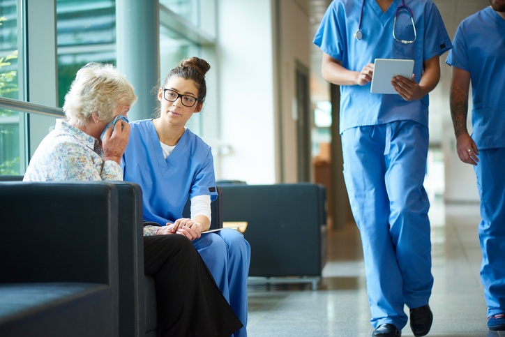 Nurse comforting a patient's family member in the hospital