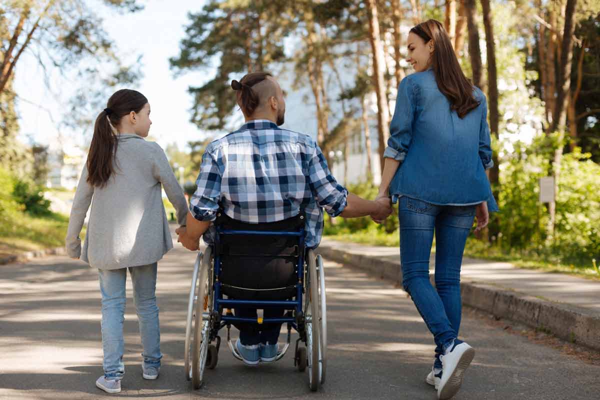 family walking with man in wheelchair